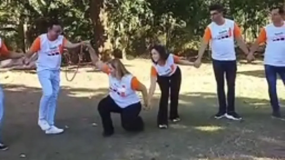 Equipe participando de dinâmica corporativa ao ar livre